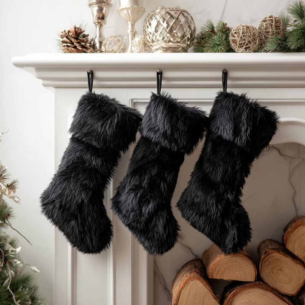Black faux fur stockings hanging on a fireplace mantle with Christmas decor.
