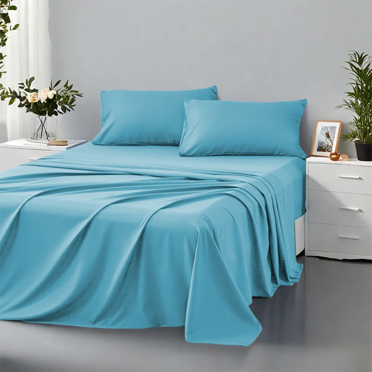 Blue bedspread and pillows on a bed in a bedroom setting with plants and decor.