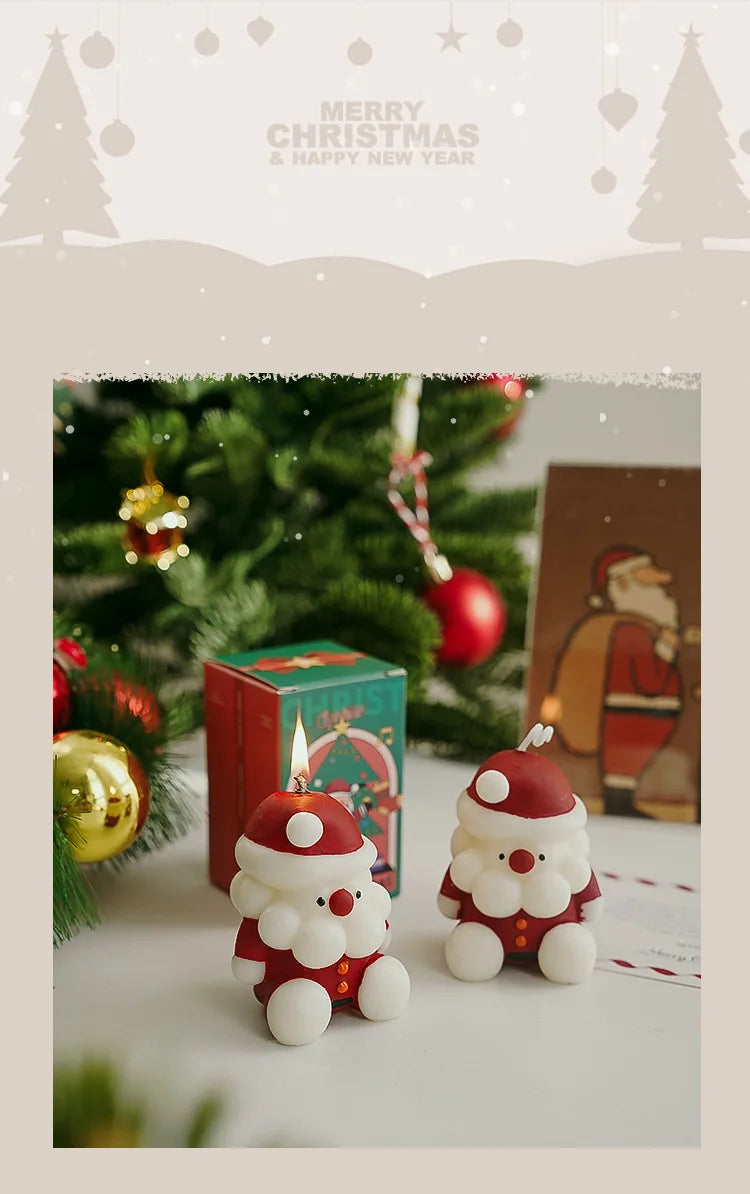 Two Santa Claus figurines with candles on a Christmas