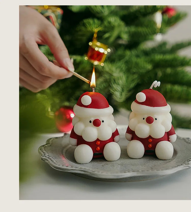 Set of two Santa Claus candle figurines being lit with a match, Christmas home decor for festive interiors.