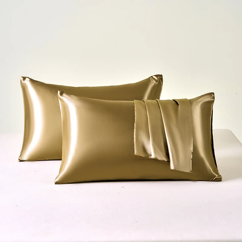 Gold satin pillowcases on a white background
