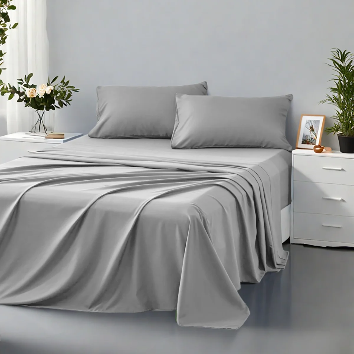 Gray bedding set on a bed in a bedroom with plants and decor.