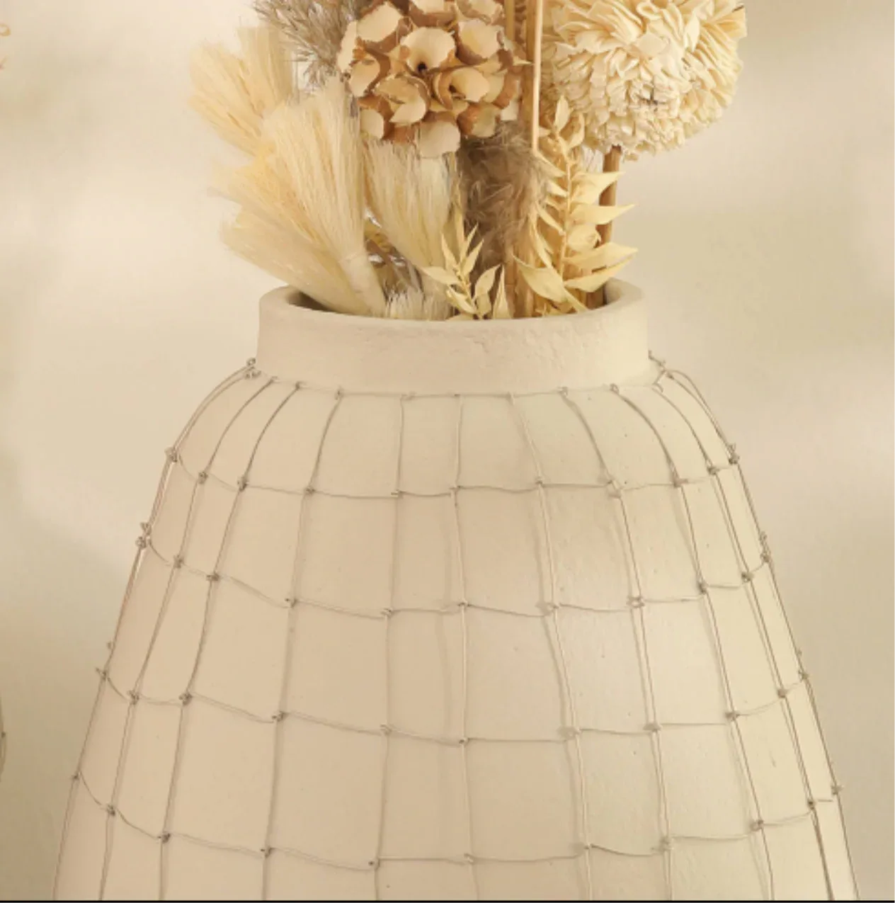 Decorative vase with dried flowers and natural textures, perfect for home decor.