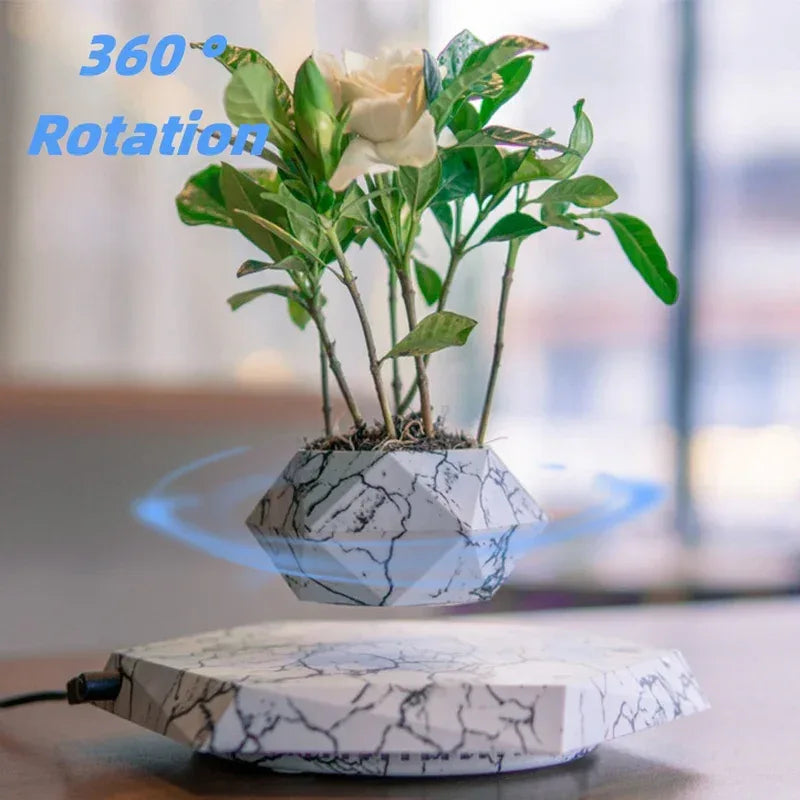 Levitating plant pot with 360° rotation feature, showcasing a marble design and vibrant greenery.