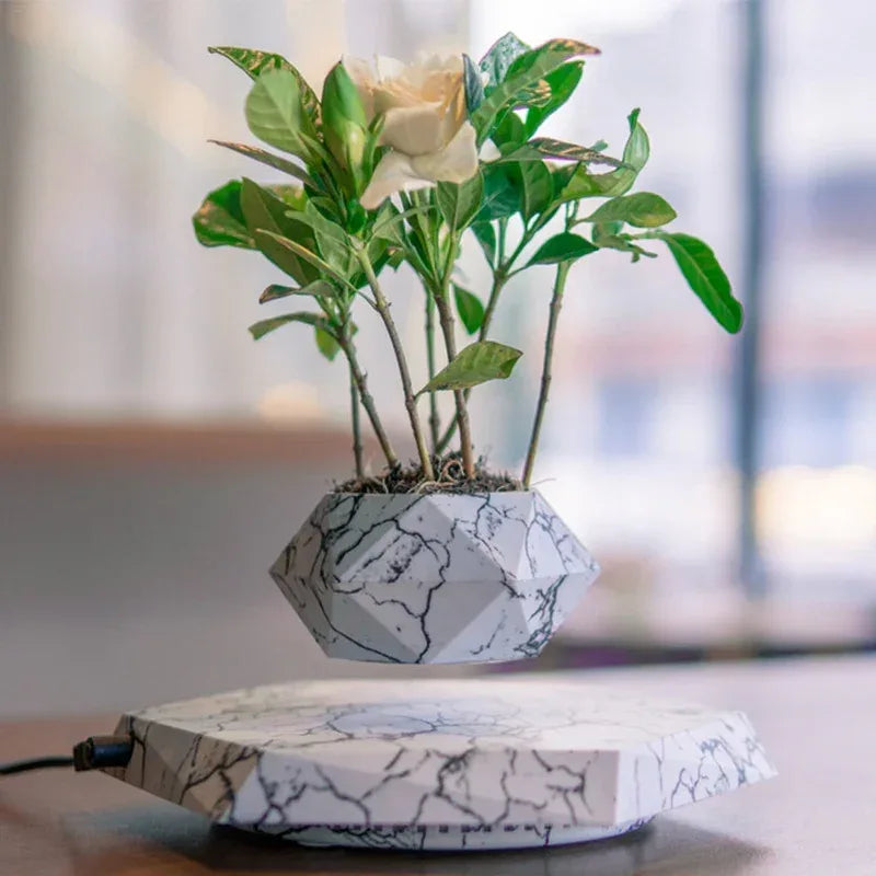 Floating planter with a marble design showcasing green plants and a white flower.